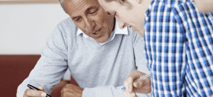 A man getting help 1-on-1 with an instructor, Instructor is explaining something on a paper.